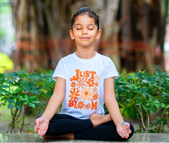 A serene child enjoying a calming meditation session in a golden and maroon space, expertly guided by Gaurav Tribedi during Nabatara's online yoga classes for beginners.