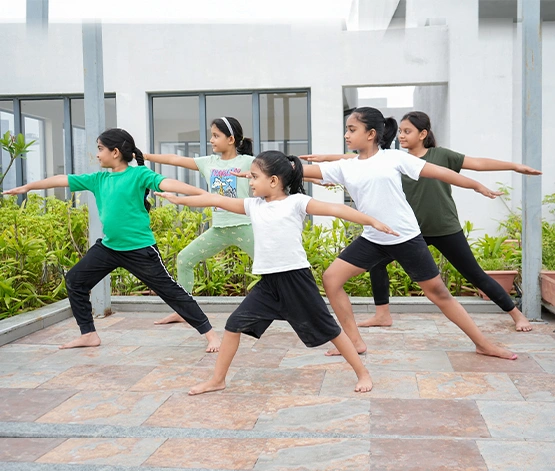 A joyful child joining the Yoga Summer Camp in a beautiful golden and maroon setting, expertly guided by Gaurav Tribedi through Nabatara's online yoga classes for beginners.